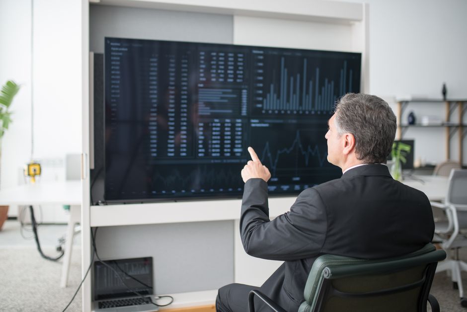 Director de marketing B2B frente a pantalla con múltiples métricas de proveedores, representando el costo operativo real de la stasis en la selección de agencia de marketing
